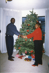 Photograph of Two Individuals Holding Hands In Front of a Christmas Tree by Las Vegas Chapter of the National Bar Association